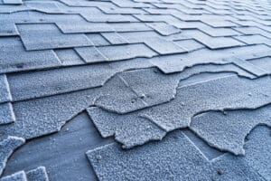  Asphalt Roofing Shingles roof damage covered with frost.