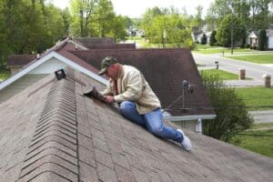 Roofer hammering shingles onto a new roof