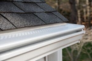 Closeup of white rain gutters with gutter guards