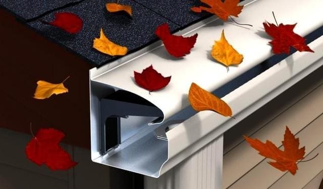 Leaves flowing over a gutter protected by gutter guards