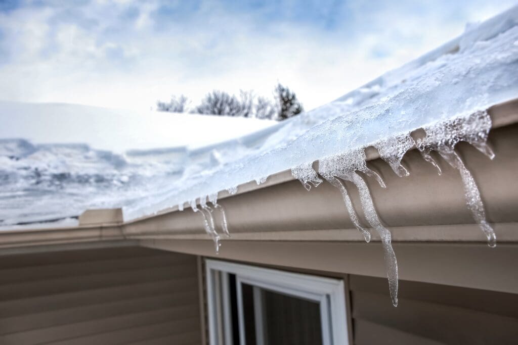 Ice dam in gutter and ice frozen on roof in winter