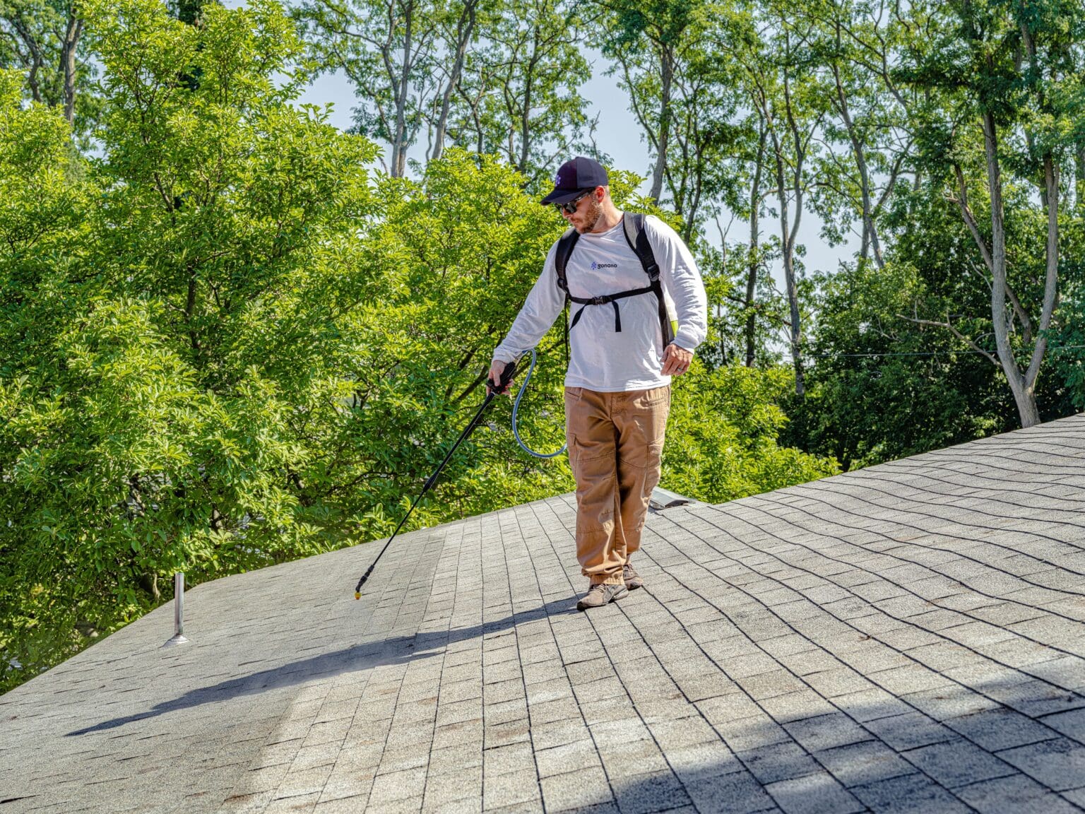 person on roof spraying gonano